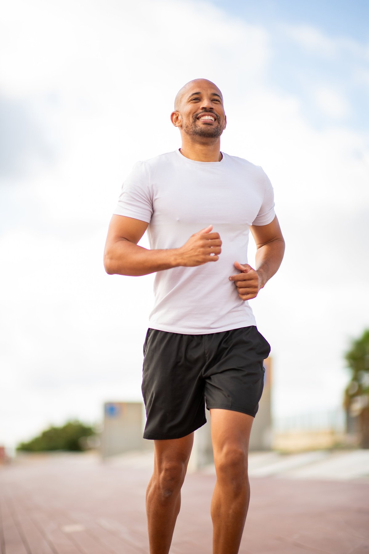 Confident jogger on a solo run under a clear sky, full body clearly visible